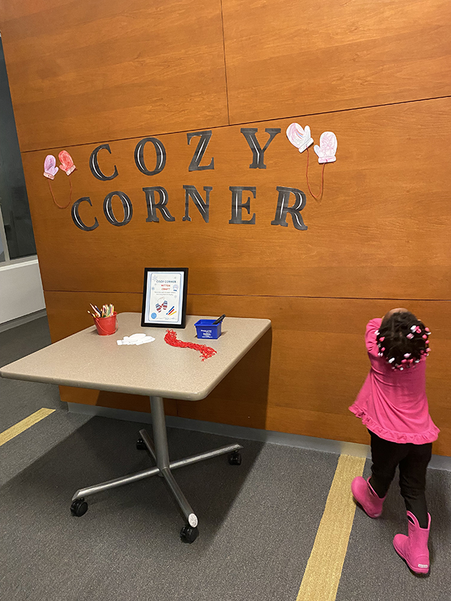 A small child walking towards the Cozy Corner table