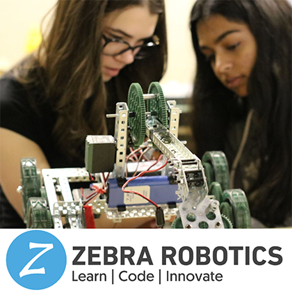 2 young girls building a robot